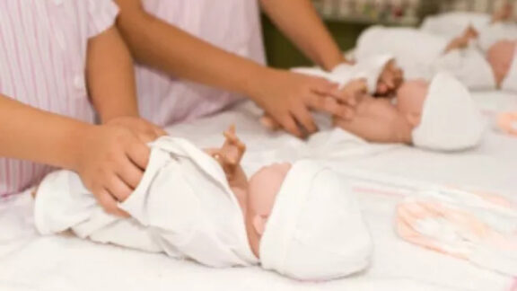 Doi bebeluși culcați pe pat