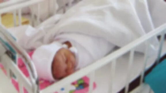 Bebeluș culcat pe un pat