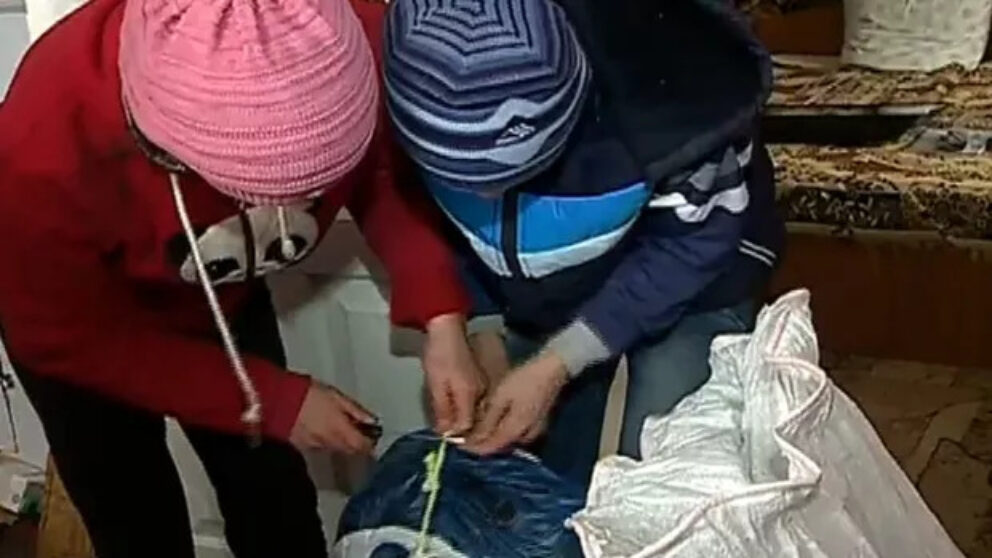 Doi copii care stau aplecați