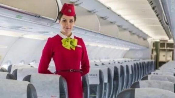 De ce crezi că ţin stewardesele mâinile la spate atunci când pasagerii urcă în avion?