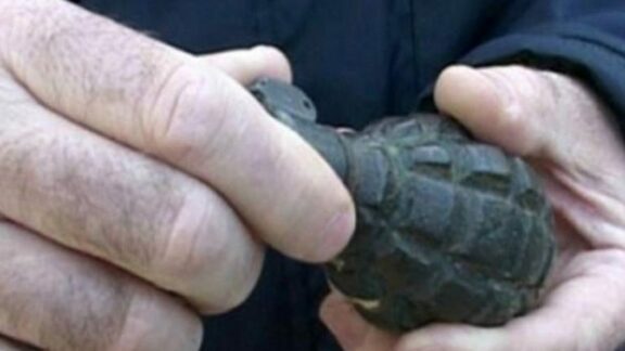 o grenadă în mâinile unui bărbat