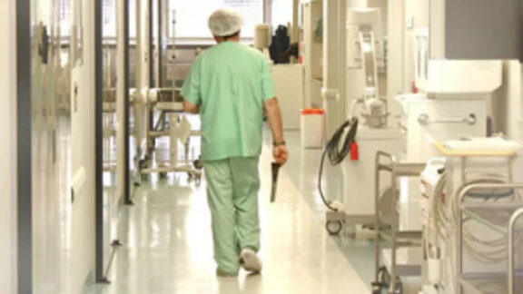 Un om care merge cu spatele prin spital