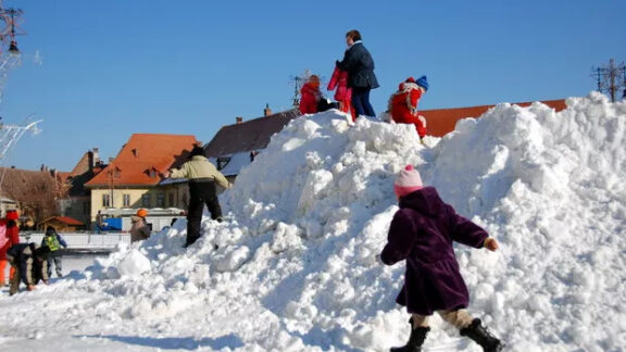Copii ce se joacă în zăpadă